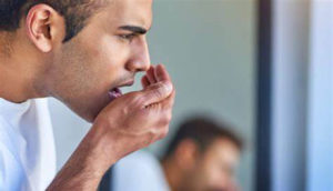 Man observing bad breath from his mouth